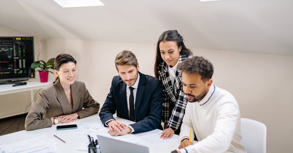 A diverse team of professionals collaborating and discussing work in a modern office setting.